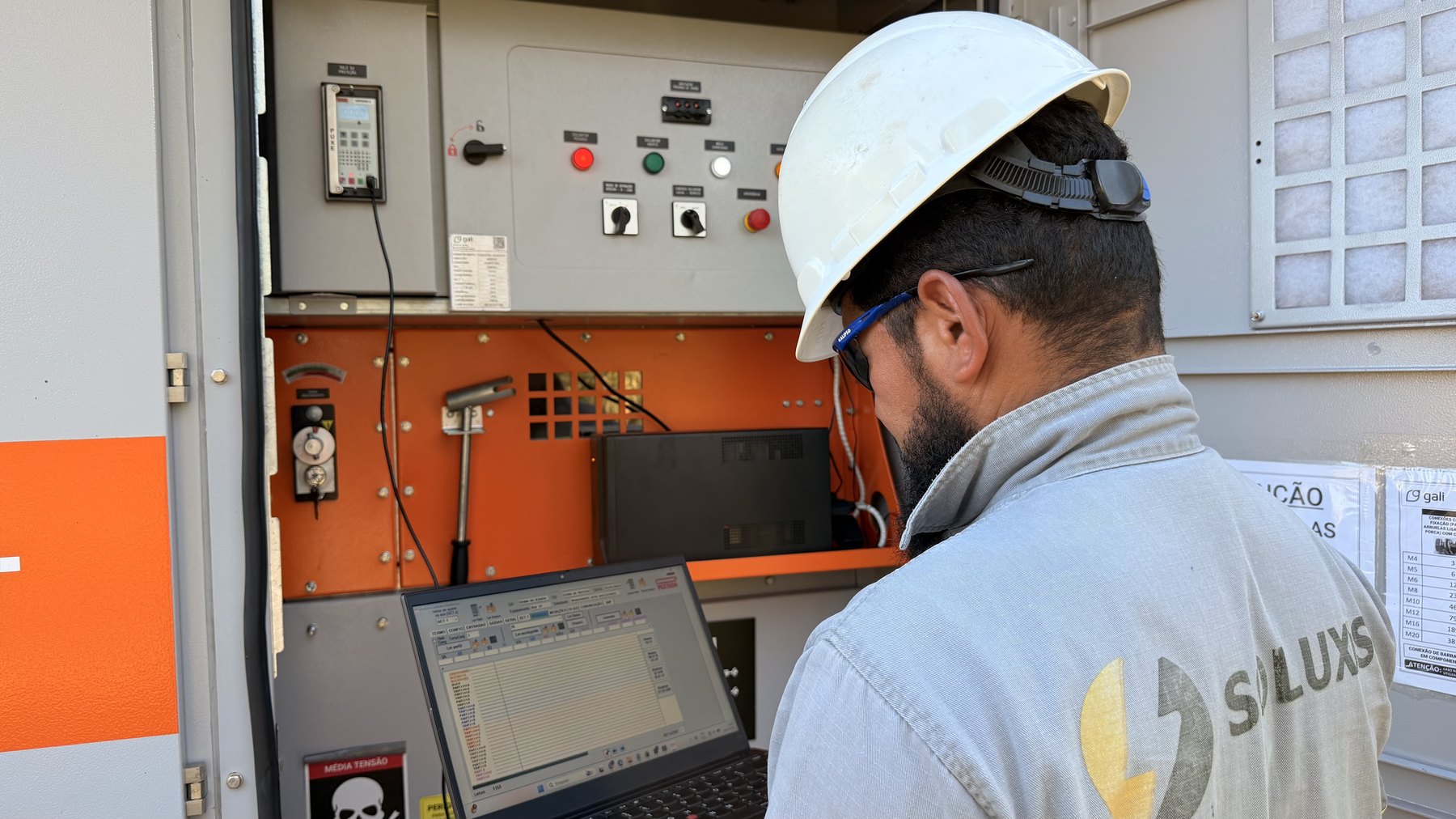 Técnico da Soluxis parametrizando painel elétrico em campo
